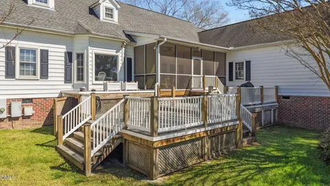 a view of a chair and table in the back yard of the house