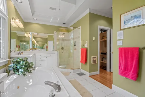 a bathroom with a tub sink and mirror