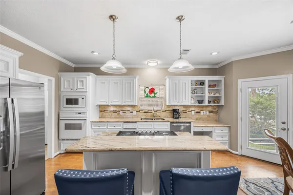 a kitchen with granite countertop a stove and white cabinets
