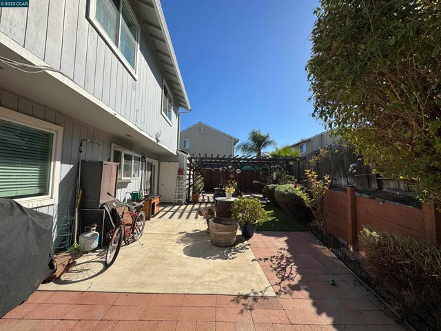 a backyard of a house with wooden fence table and chairs