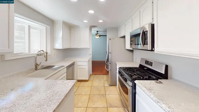 a kitchen with stainless steel appliances granite countertop a sink stove and cabinets