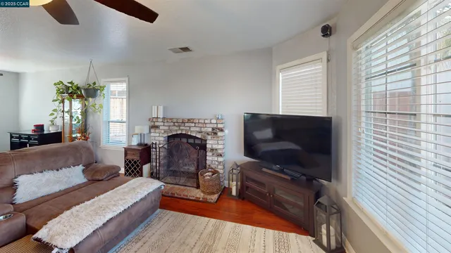 a living room with furniture a flat screen tv and a fireplace
