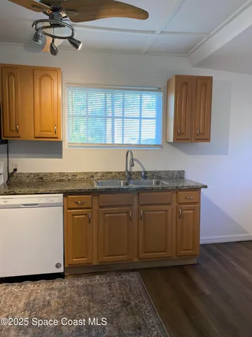 a kitchen with granite countertop cabinets stainless steel appliances a sink and a window