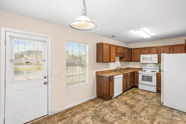 a kitchen with stainless steel appliances granite countertop a refrigerator and a stove top oven