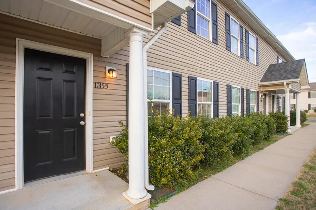 a view of a brick house with potted plants