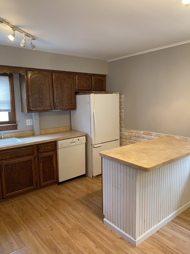 329 Douglas Road Batavia, IL 60510 - Photo 8 of 23 a kitchen with a refrigerator a stove top oven a sink and dishwasher with wooden floor