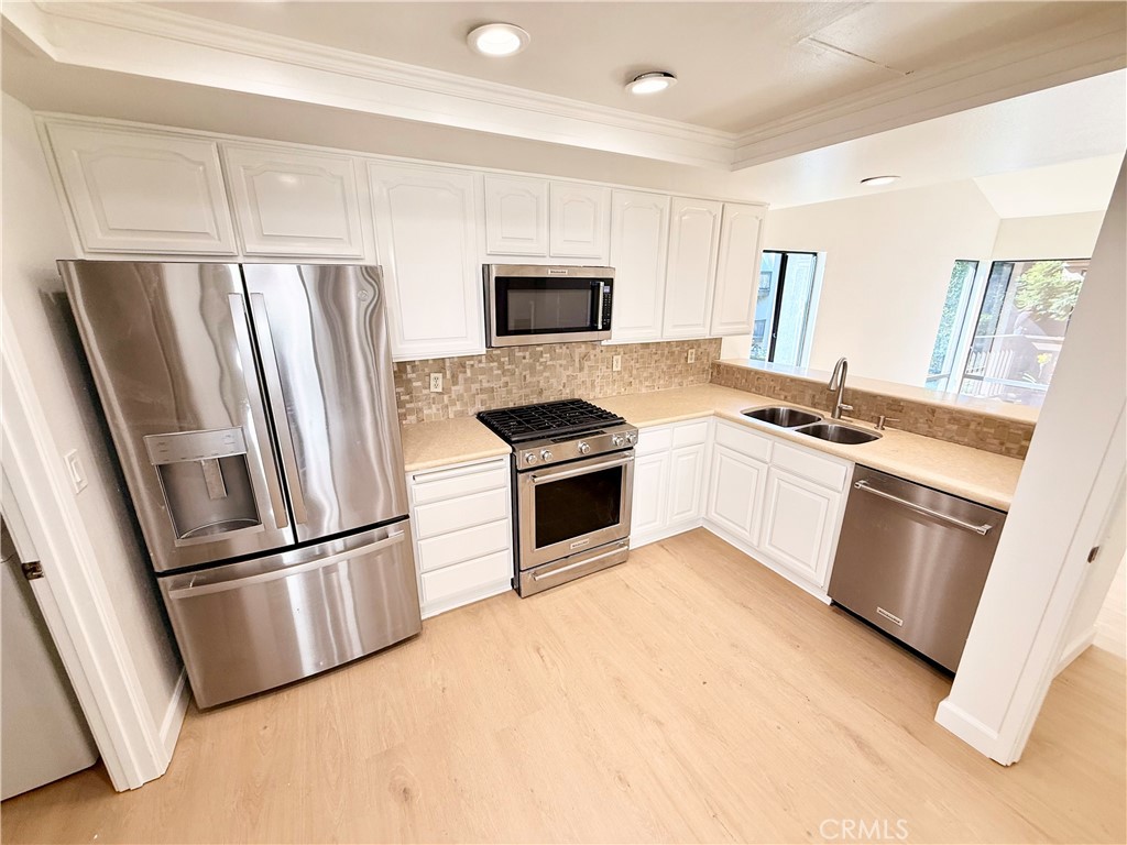 15 Rana Irvine, CA 92612 - Photo 5 of 15 a kitchen with white cabinets and stainless steel appliances