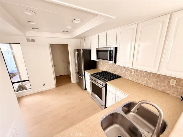 a kitchen with stainless steel appliances granite countertop a refrigerator and a stove top oven