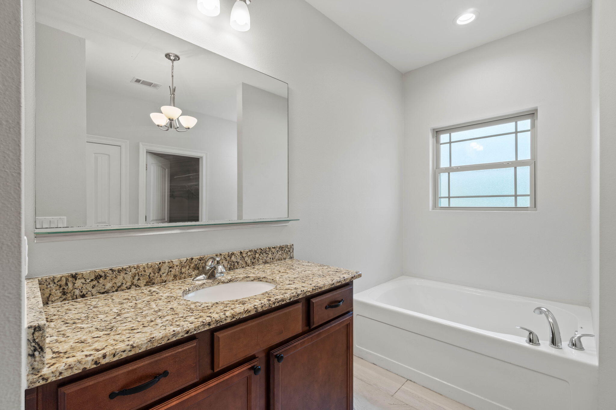 6000 Fiori Drive Crestview, FL 32539 - Photo 26 of 44 a bathroom with a granite countertop bathtub a sink and a mirror