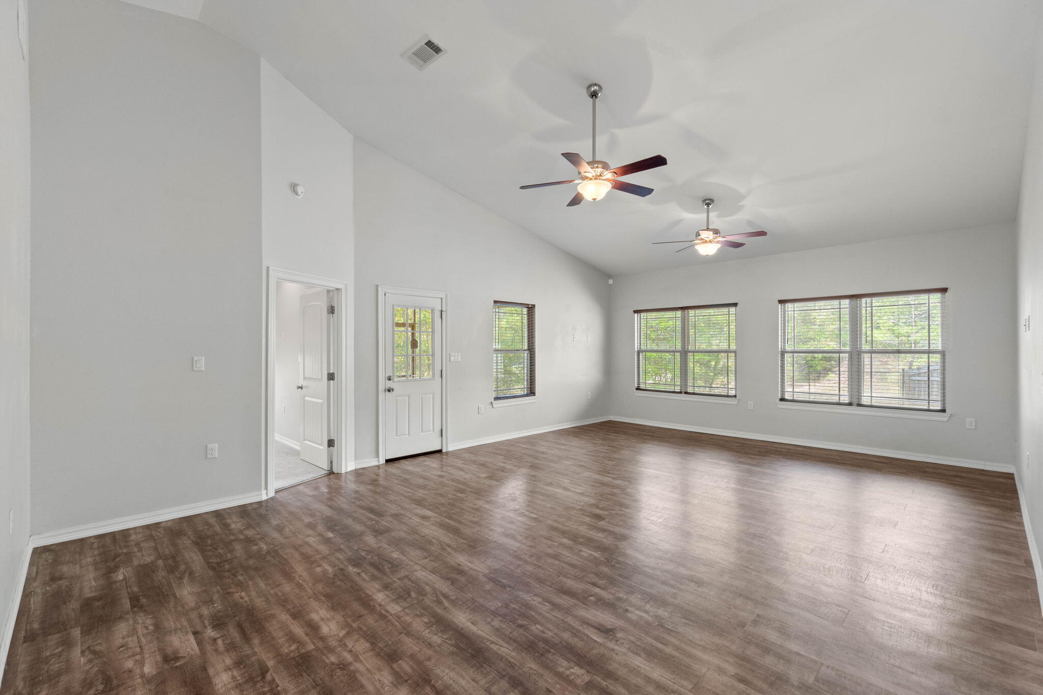 6000 Fiori Drive Crestview, FL 32539 - Photo 6 of 44 a view of an empty room with a window and wooden floor