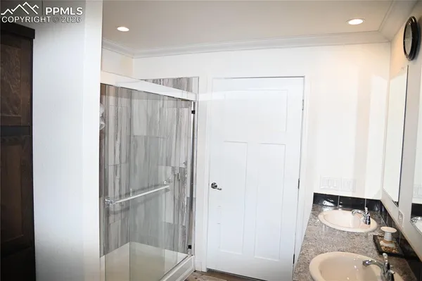 a bathroom with a granite countertop sink a toilet and shower