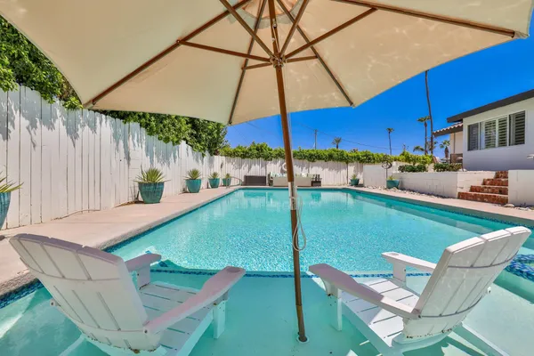 a patio with a table and chairs under an umbrella