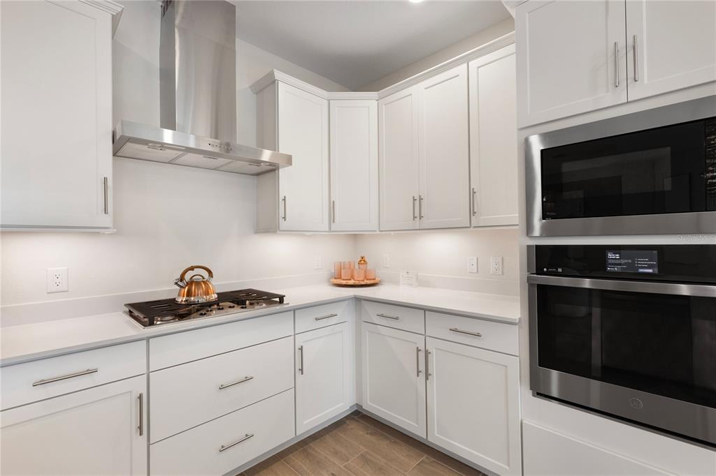 7157 Inlet Isles Lakewood Ranch, FL 34202 - Photo 6 of 26 a kitchen with white cabinets and black appliances