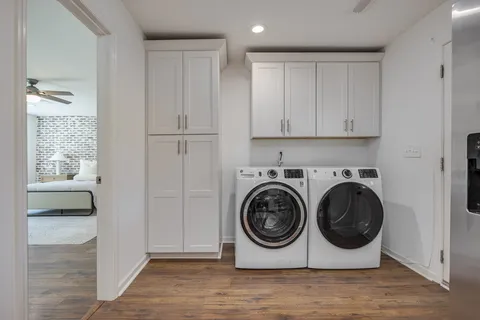 a utility room with wooden floor and mirror