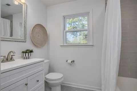 a bathroom with a toilet a sink and a window