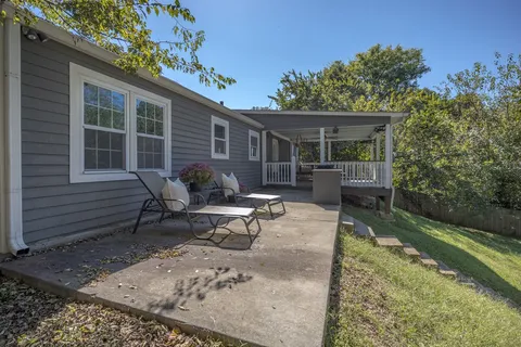 a view of a house with backyard sitting area and garden