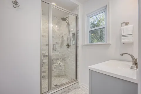 a bathroom with a shower sink and mirror
