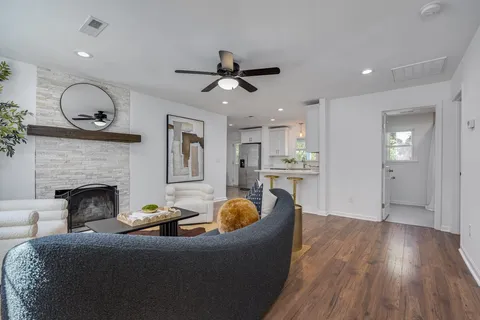 a living room with furniture a fireplace and wooden floor