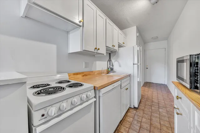 a kitchen with granite countertop a stove sink and cabinets