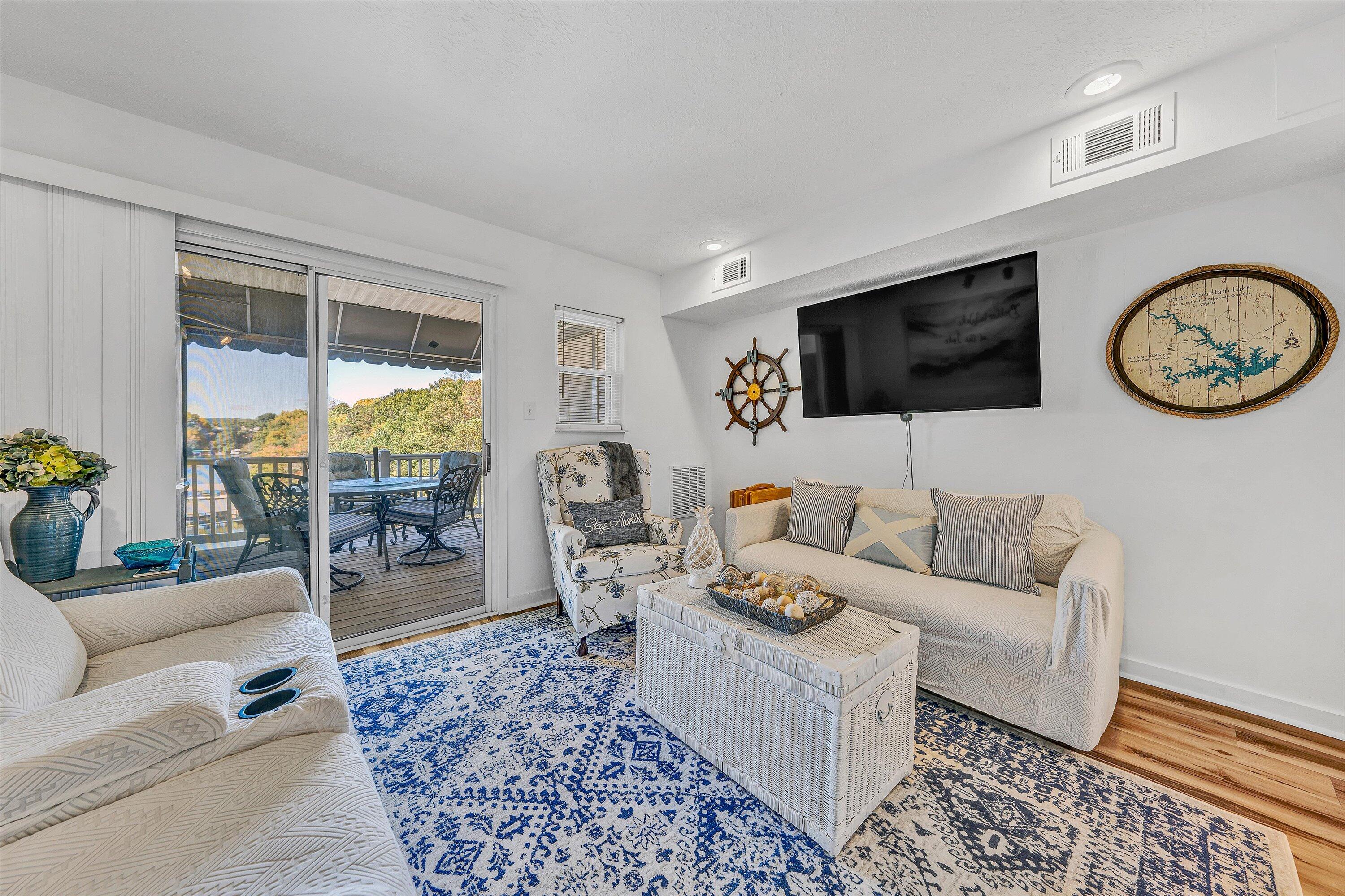 1089 Bluewater Drive, Unit 414 Moneta, VA 24121 - Photo 12 of 30 a living room with furniture a rug and a flat screen tv