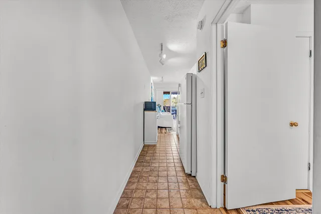 a hallway with a white cabinets and wooden floor