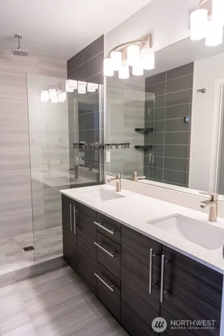 a bathroom with a double vanity sink mirror and shower