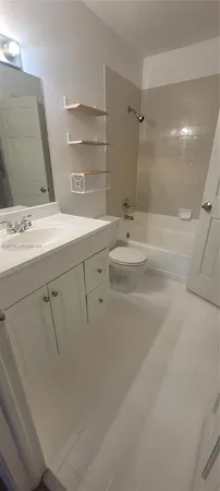 a view of a kitchen has white cabinets and a stove top oven