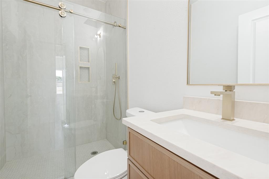 3913 Blue Ridge Boulevard Dallas, TX 75233 - Photo 18 of 25 Floating vanity with integrated sink, rectangular mirror, and light-toned faucet