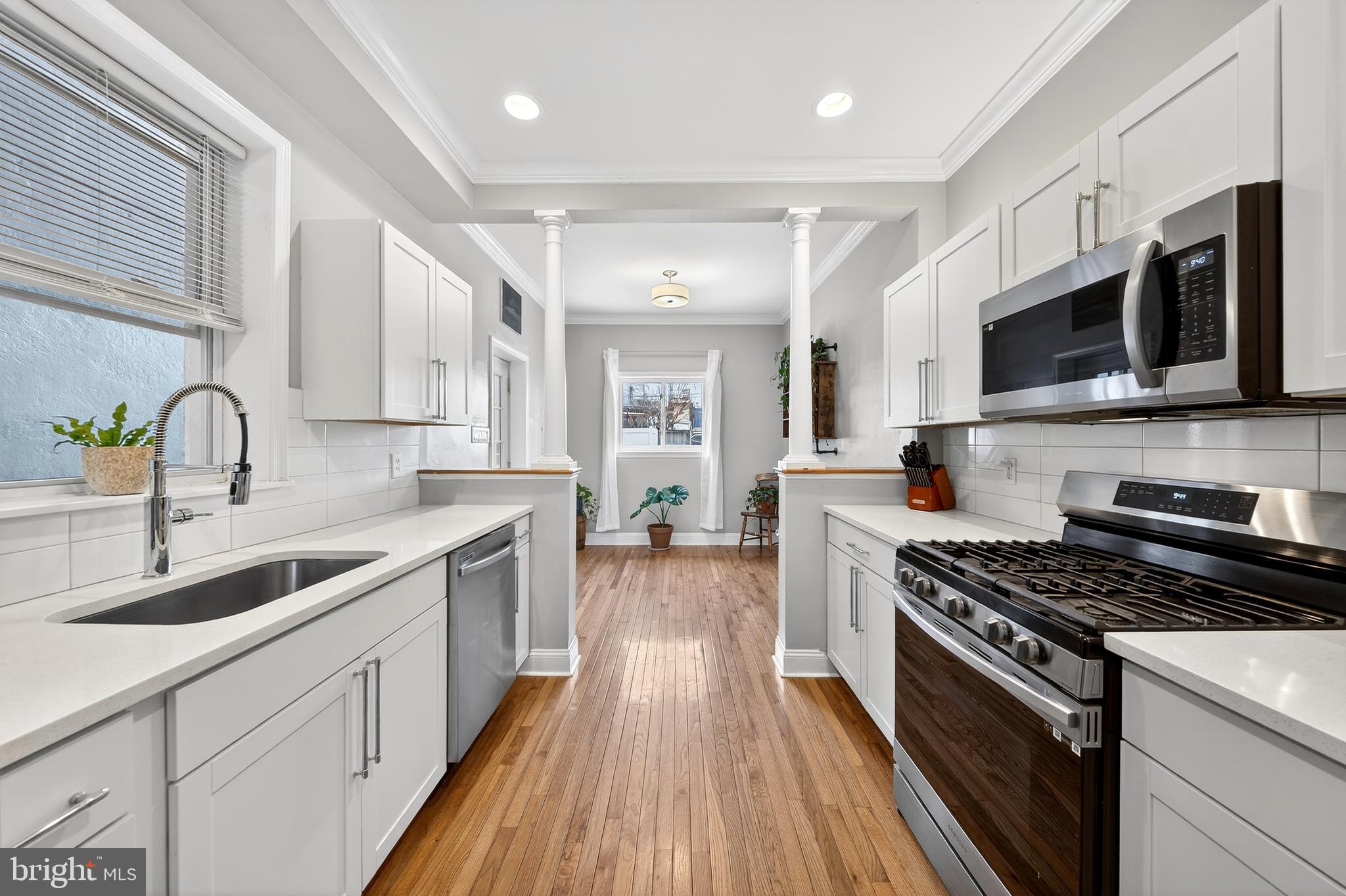 7 East Fort Avenue Baltimore, MD 21230 - Photo 14 of 73 a kitchen with stainless steel appliances a sink dishwasher a stove top oven a refrigerator with wooden floors and cabinets