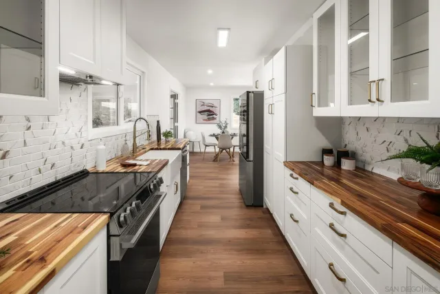 a large kitchen with stainless steel appliances a stove a sink dishwasher and cabinets with wooden floor