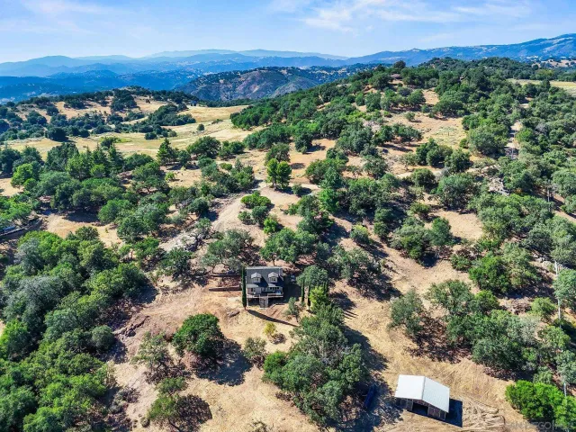 an aerial view of residential houses with outdoor space and trees