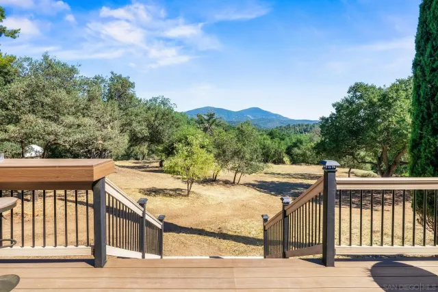a view of a balcony with wooden floor and fence