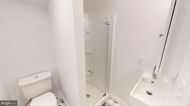 a white toilet sitting next to a bath tub
