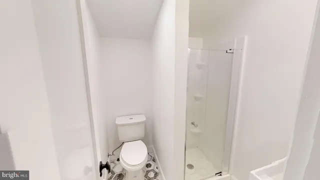 a bathroom with a granite countertop toilet and a shower