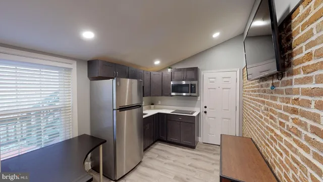 a kitchen with stainless steel appliances kitchen island granite countertop a refrigerator and a sink