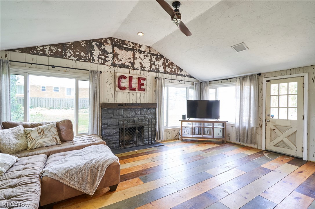 780 Bates Road Rocky River, OH 44116 - Photo 5 of 35 Vaulted ceiling room featuring multi-tone wood-finish flooring, a stone fireplace, and shiplap walls