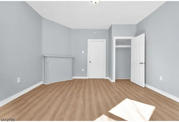 a view of a big room with wooden floor and cabinet