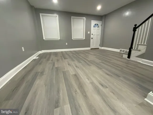 a view of an empty room with wooden floor