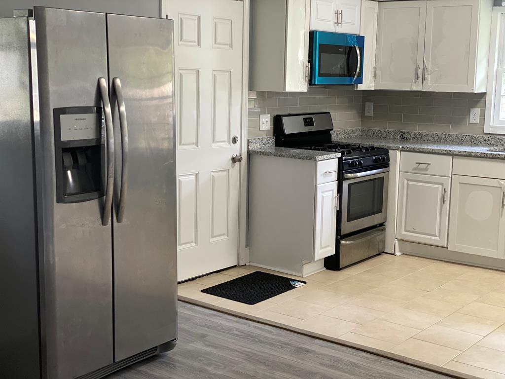 1061 Dunbar Avenue Columbus, GA 31906 - Photo 17 of 23 a kitchen with a refrigerator stove and white cabinets