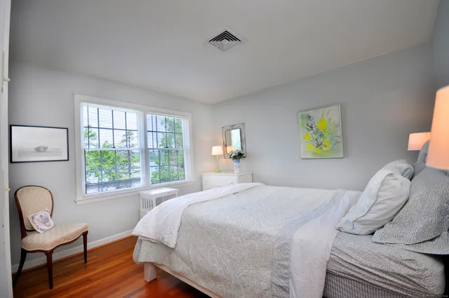 a bedroom with a bed chair and window