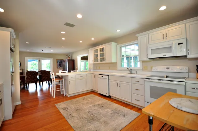 a kitchen with white cabinets and chairs