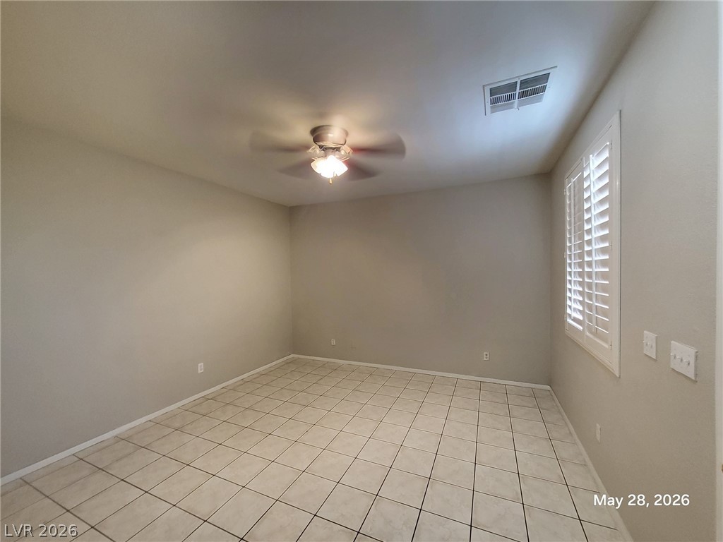 9843 West Overlook Ridge Avenue Las Vegas, NV 89148 - Photo 5 of 19 A well-lit room offers clean tile flooring and natural illumination through louvered windows.