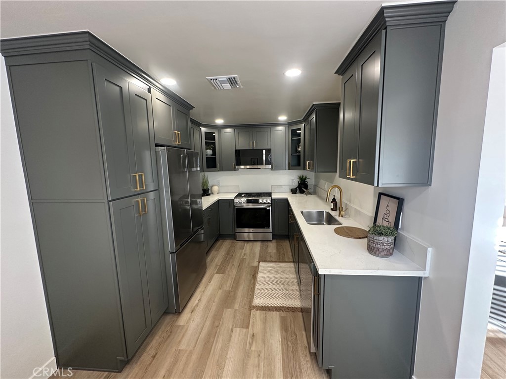 6401 Day Street Tujunga, CA 91042 - Photo 29 of 33 a kitchen with stainless steel appliances a refrigerator a sink and white cabinets