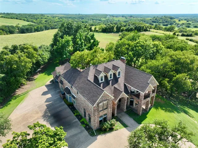 an aerial view of a house with big yard