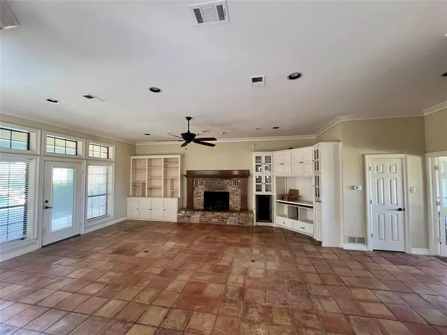 a view of a livingroom with a fireplace cabinet and windows