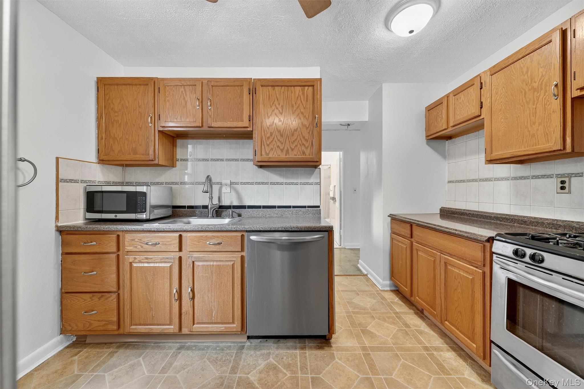 4 Sadore Lane, Unit 4U Yonkers, NY 10710 - Photo 12 of 22 a kitchen with stainless steel appliances granite countertop a stove a sink and a microwave