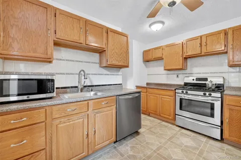 a kitchen with granite countertop a stove sink and refrigerator