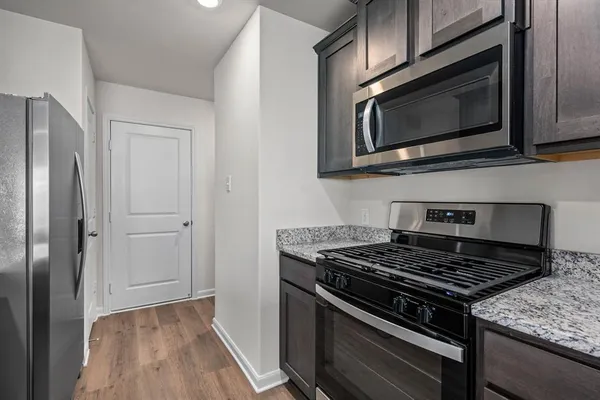 a kitchen with stainless steel appliances kitchen island a stove and a microwave