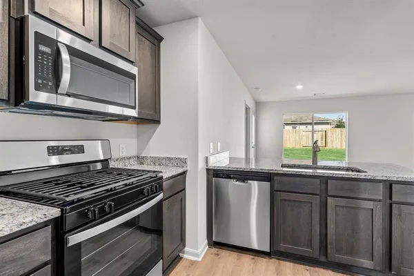 a kitchen with granite countertop stainless steel appliances and sink