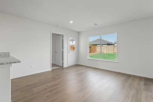 an empty room with window and wooden floor